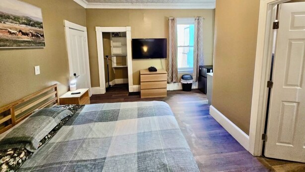 A bedroom with a bed, a TV, a dresser, a closet, and a window with curtains. - Nice large room in Federal Hill (Providence)