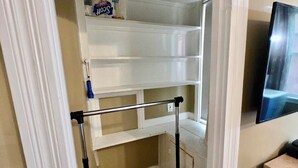 A narrow stairway leading to a storage area with shelves and a television on the wall. - Nice large room in Federal Hill (Providence)