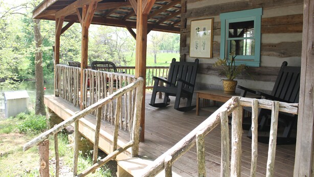 A wooden deck with a railing, a bench, and a table with chairs. - Peace Cabin- 20 min hike to Wilson Cave! (Deputy)