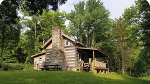 A rustic cabin with a stone chimney, wooden exterior, and a porch. - Peace Cabin- 20 min hike to Wilson Cave! (Deputy)