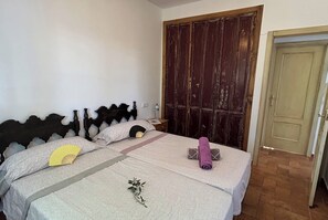 Une chambre à coucher avec un lit, une armoire en bois et une porte.
