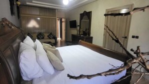 Ein Schlafzimmer mit einem großen Bett, einem Holzkopfende und einer Deckenleuchte.