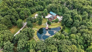 Vue aérienne d’une propriété dotée d’une piscine, d’un quai pour bateaux et d’un vaste espace vert.