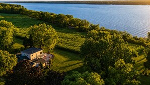 A house with a large lawn and a view of a lake. - Serene | Hot Tub | Seneca Lake Access | Seneca Wine Trail (Geneva)