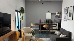 A modern living room with a flat-screen TV, a sofa, a coffee table, and a dining area in the background. - Peaceful studio with AC in charming El Paso (El Paso)