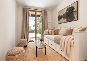 A modern living room with a sofa, a coffee table, and ottomans. - Historic Mazot Retreat by Mrs Miggins – Charming Alpine Stay in Crans-MontanaHistoric Mazot Retreat (Lens)