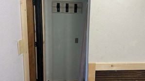 A hallway with a wooden door frame, a light switch, and a wall-mounted electrical outlet.