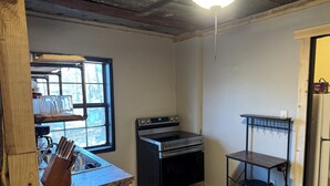 A kitchen with a built-in oven, a window with a view, and a wooden countertop.