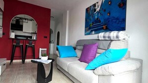 A living room with a sofa, a coffee table, and a painting on the wall. - Penthouse city sea and sun (Torrevieja)