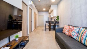 Una sala de estar moderna con un sofá, una mesa de centro y un comedor con sillas y una mesa.