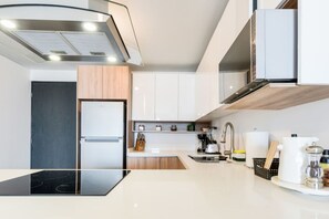 Eine moderne Küche mit Backofen, Spüle und Kaffeemaschine.