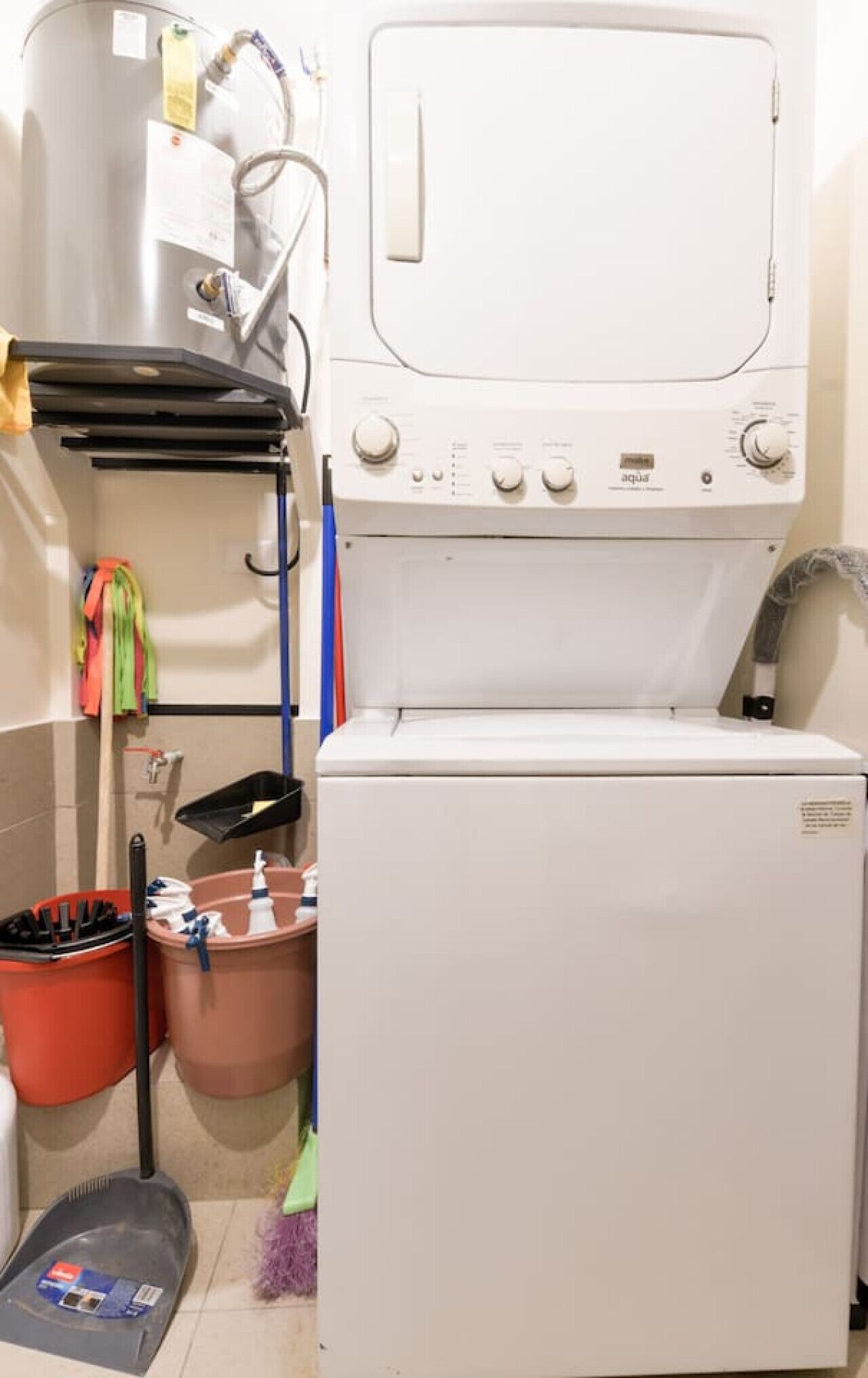 Une buanderie équipée d’un lave-linge, d’un sèche-linge et d’un chauffe-eau.