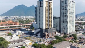 Un immeuble de grande hauteur doté d’une architecture moderne, dont la façade est ornée d’une grande enseigne portant le mot « HEROES ».