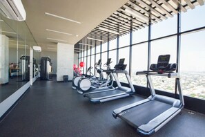 A gym with treadmills, exercise balls, and a view of the city through large windows. - ¡A pasos de Paseo Santa Lucía! 2 Camas Queen y Gym (Monterrey)
