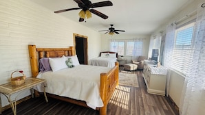A bedroom with a wooden bed, a nightstand, a chair, a desk, a ceiling fan, and a window with blinds. - Quiet Country Getaway ,quiet, and spacious getaway (Belen)
