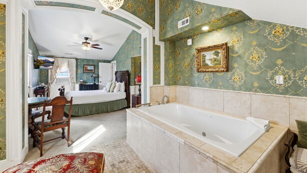 Une chambre avec une grande baignoire, un bureau et une chaise.