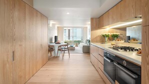 Una cocina moderna con armarios de madera, un comedor con mesa y sillas, y vistas a un balcón.
