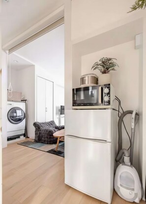 Cocina compacta con microondas, refrigerador y aspiradora.