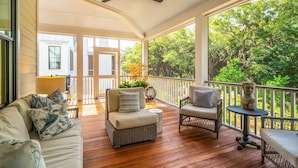 A covered porch with wicker furniture, a ceiling fan, and a view of trees. - 8311 Jack Island Dr – 4 BR / Walk to Spring House / Elevator + Screened Porch (Johns Island)