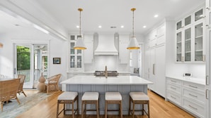 A spacious kitchen with a large island, white cabinetry, and pendant lighting. - 8311 Jack Island Dr – 4 BR / Walk to Spring House / Elevator + Screened Porch (Johns Island)