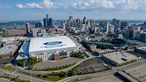 A large stadium with a prominent Ford logo, surrounded by a cityscape with high-rise buildings.