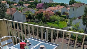 En balkon med et bord, stole og en vandflaske.