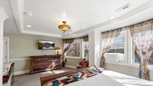 Un dormitorio con cama, cómoda y ventana con cortinas.
