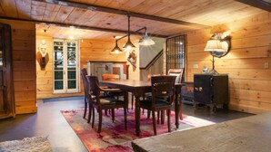Un intérieur en bois avec une table à manger, des chaises et un tapis.