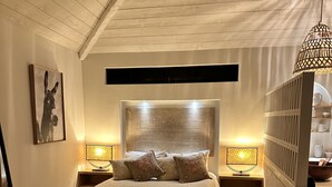 A bedroom with a bed, bedside lamps, a patterned rug, and a headboard.