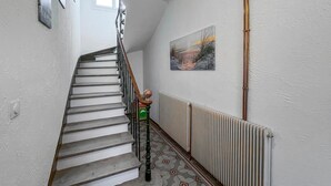 A staircase with a radiator and a painting on the wall. - Maison av. piscine proche Uzès (Saint Laurent la verne)