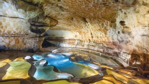 A cave interior with natural rock formations and a pool of water. - Maison av. piscine proche Uzès (Saint Laurent la verne)