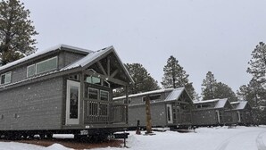 A row of cabins with a covered porch and a snow-covered ground. - Luxury Cabin with Mountain View 3B (Williams)