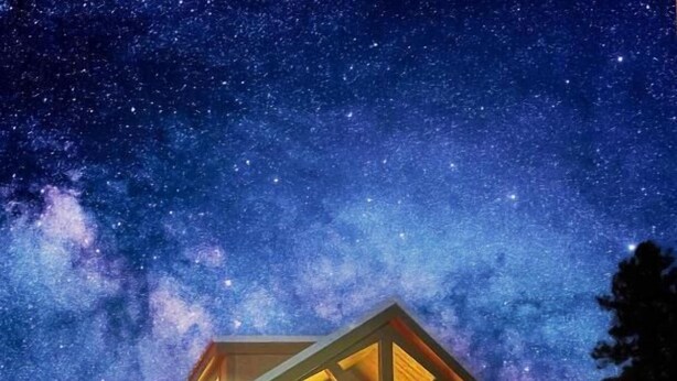 A cabin with a starry night sky, a wooden exterior, and a lit porch. - Luxury Cabin with Mountain View 3B (Williams)