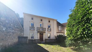 A multi-story building with a balcony, a stone wall, and a well-maintained hedge. - Beautiful home in Cessenon sur Orb with WiFi (Cessenon sur Orb)