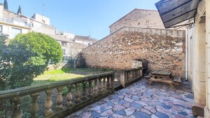 A stone building with a tiled courtyard, a wooden bench, and a metal railing. - Beautiful home in Cessenon sur Orb with WiFi (Cessenon sur Orb)