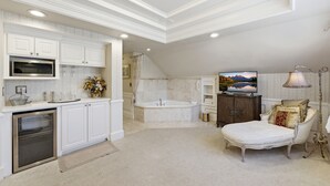 Een ruime badkamer met een bad, douche en toilet.