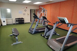 A gym with treadmills, a bench, and dumbbells. - La Quinta Inn & Suites Indianapolis Airport West (Plainfield)