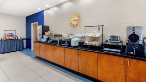 A breakfast bar with various food items and appliances. - La Quinta Inn & Suites Indianapolis Airport West (Plainfield)