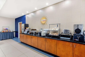 A breakfast bar with various food items and appliances. - La Quinta Inn & Suites Indianapolis Airport West (Plainfield)