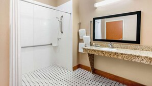 A bathroom with a shower, toilet, sink, and mirror. - La Quinta Inn & Suites Indianapolis Airport West (Plainfield)