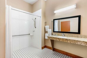 Un baño con ducha, inodoro, lavabo y espejo.