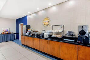 A breakfast bar with various food items and appliances. - La Quinta Inn & Suites Indianapolis Airport West (Plainfield)