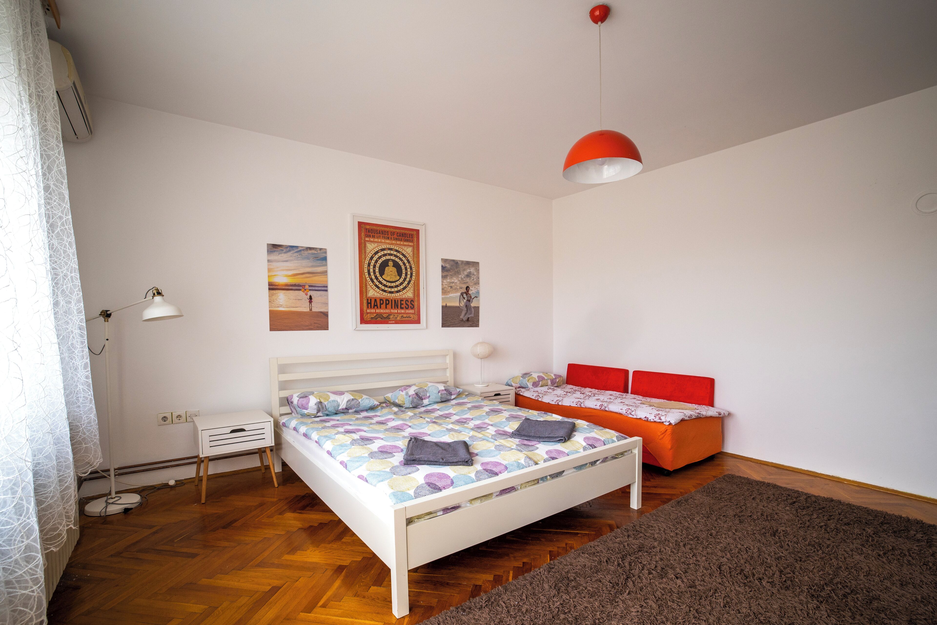 Ein Schlafzimmer mit einem Bett, einem Nachttisch und einer roten Bank.