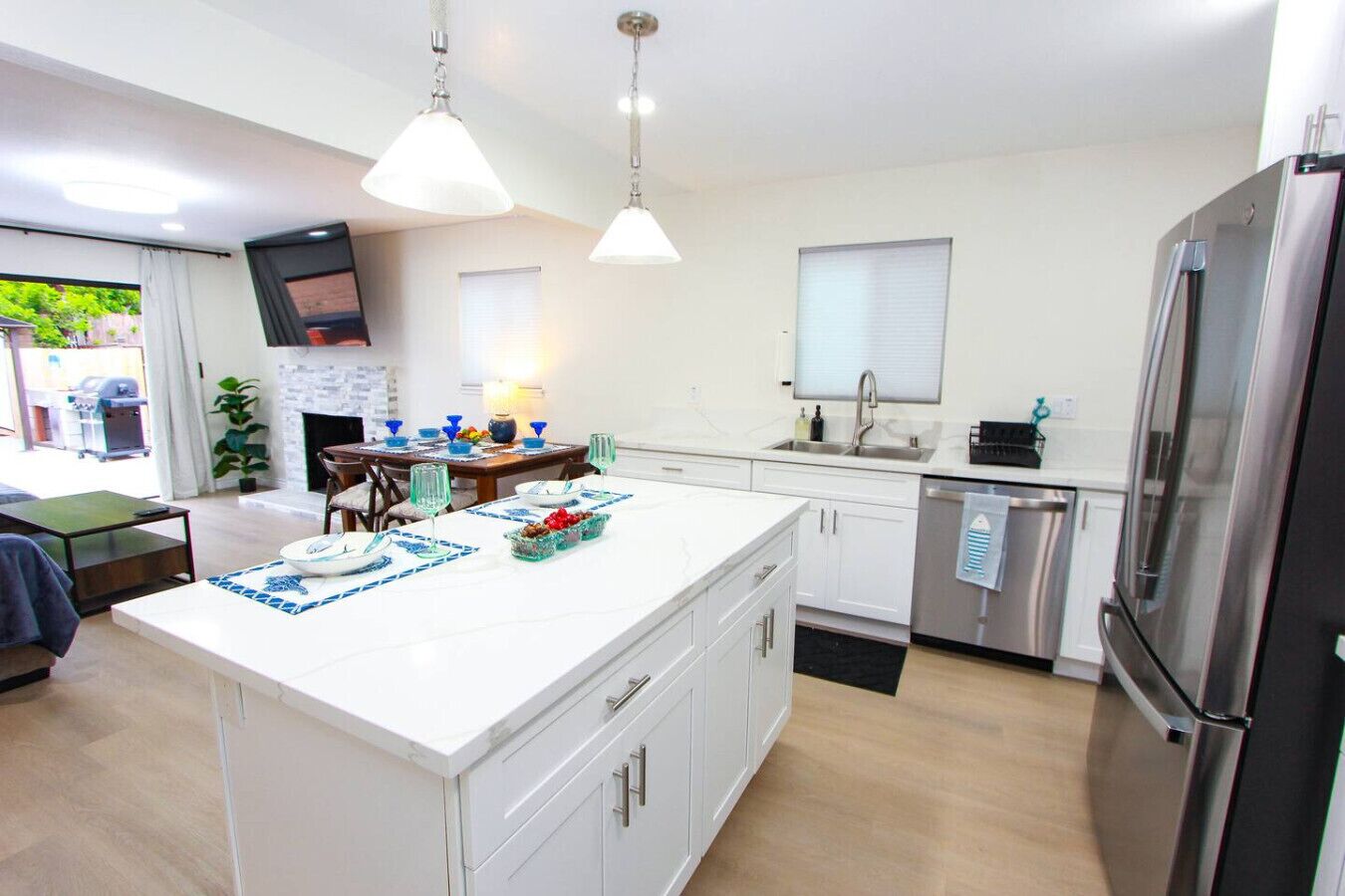 A modern kitchen with a central island, stainless steel appliances, and a dining area with a table and chairs.