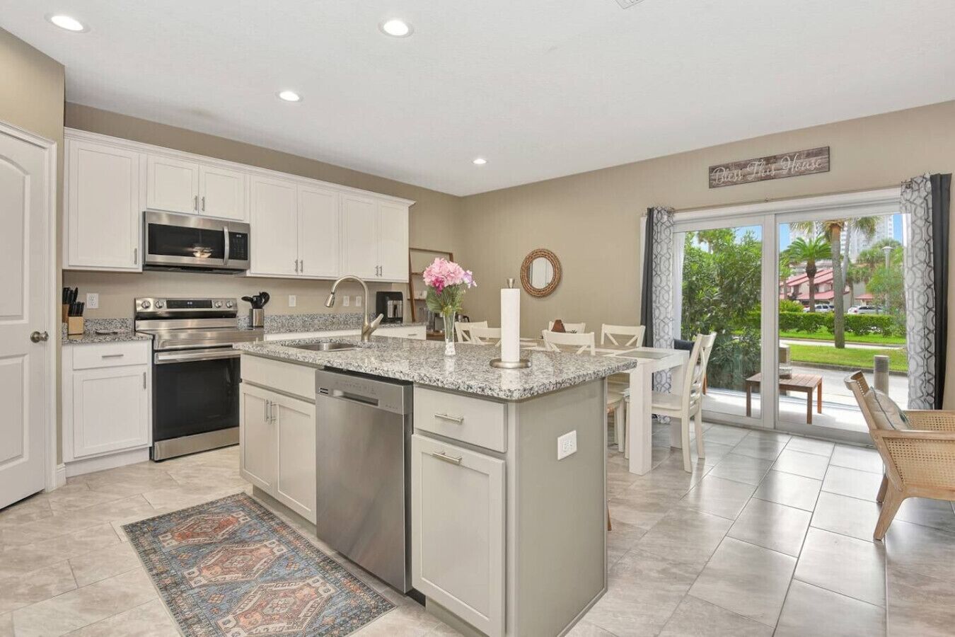 A modern kitchen with white cabinets, stainless steel appliances, and a granite countertop.