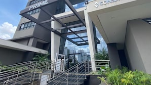 Un edificio moderno con señalización 'PRIME' y 'CONSBASE', que presenta una escalera destacada y fachada de vidrio.