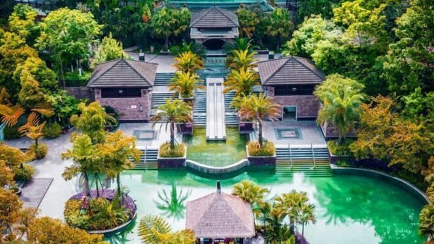 Un complexe hôtelier doté d’une piscine centrale, de plusieurs villas pour les clients et d’une végétation luxuriante.