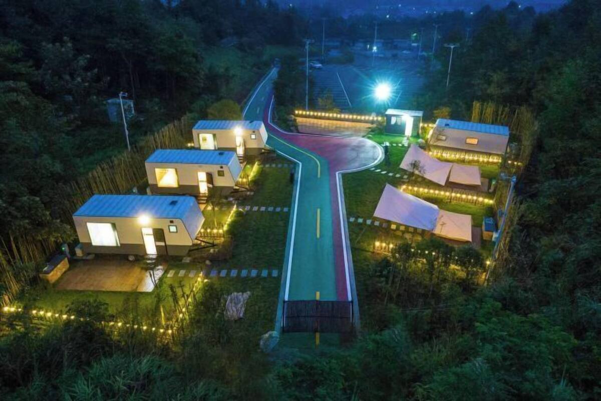 A modern resort with multiple cabins, a winding road, and a well-lit pathway.