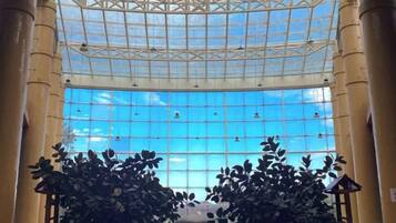 A spacious atrium with a high ceiling and a large glass wall.