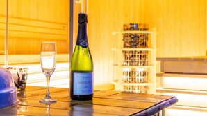 Een fles CAVA Montecasin Brut wijn en een glas op een houten tafel in een kamer met houten lambrisering.